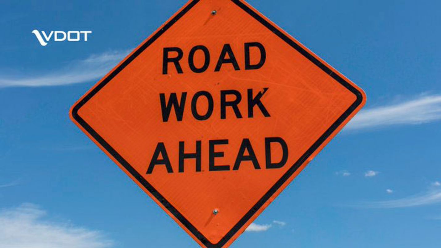 orange sign with the words road work ahead
