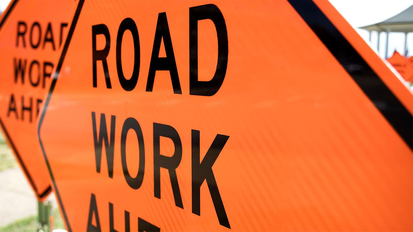 orange signs reading road work ahead