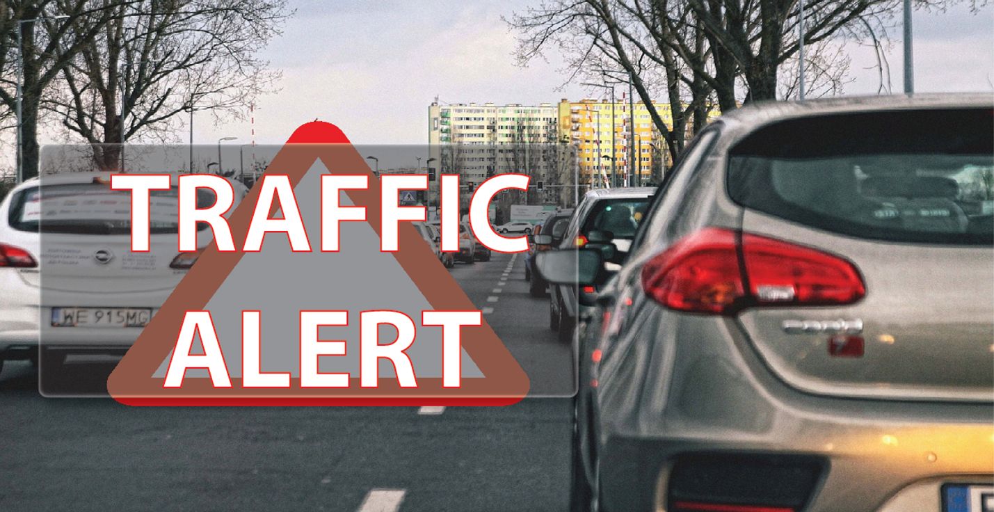 Image of a car on a road with text that says traffic alert