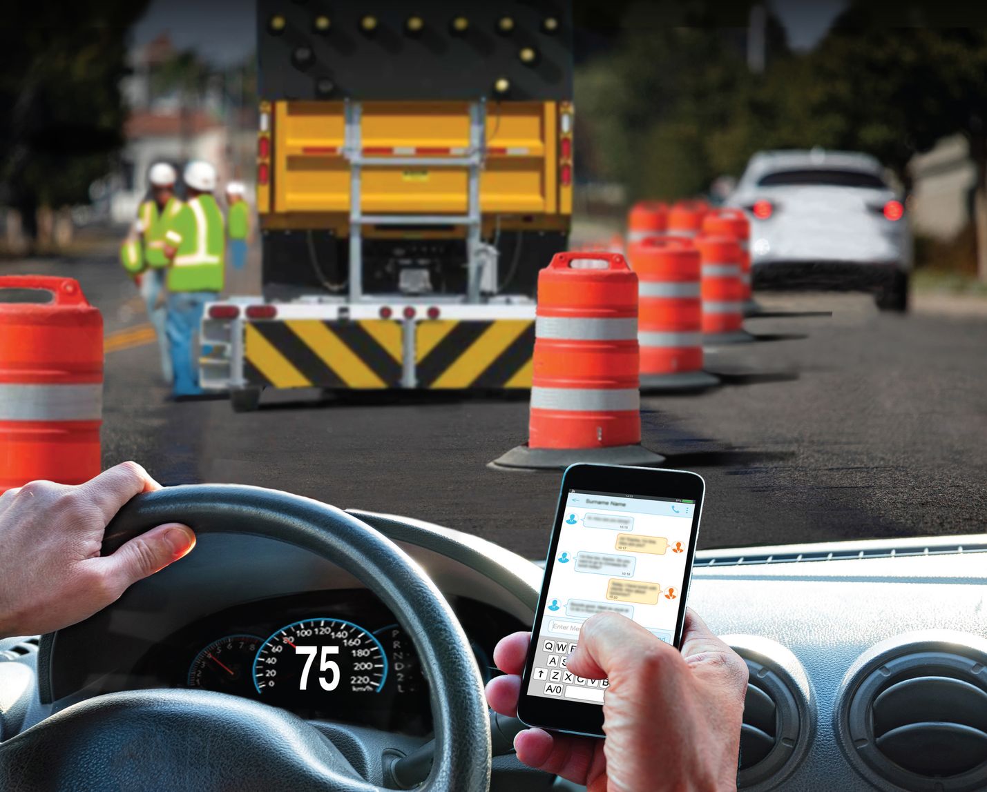 A driver looks at their phone as they approach a work zone