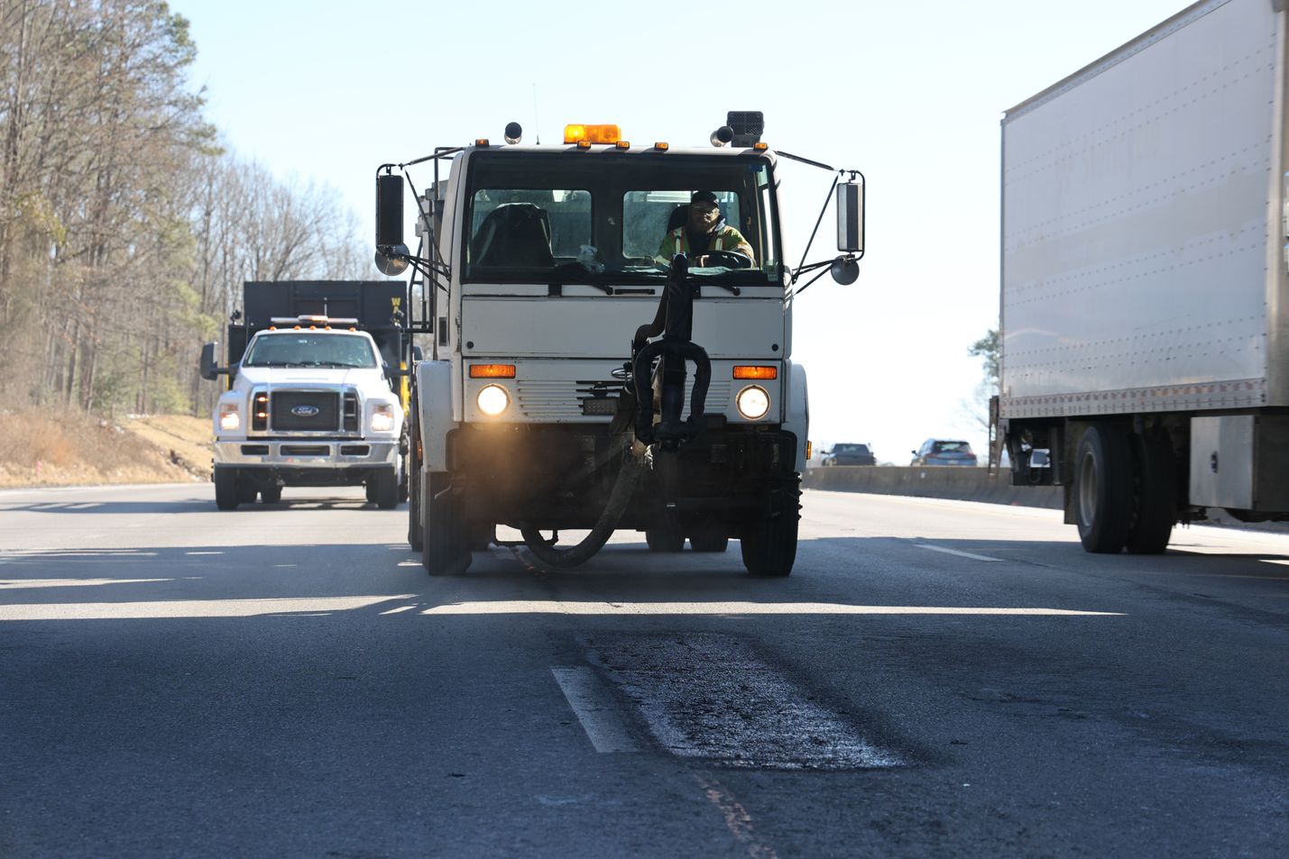 A maintenance truck parked behind a patched pothole