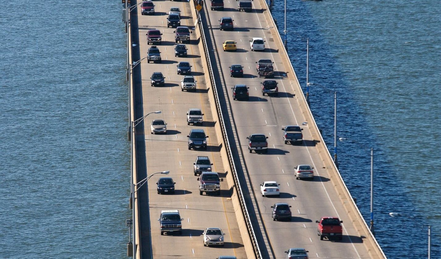 Cars drive across a bridge overtop water