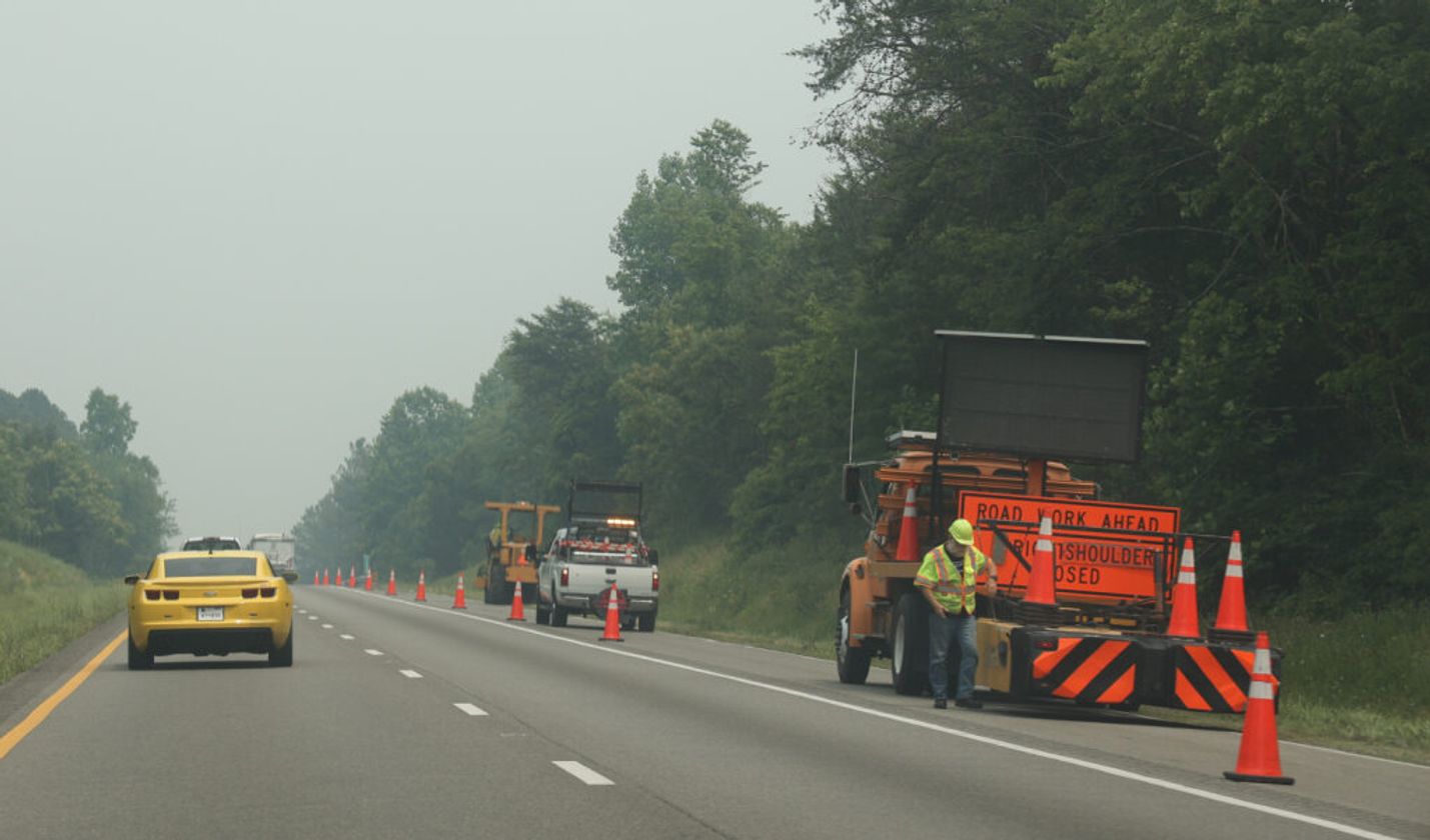 work zone on highway with yellow car on road