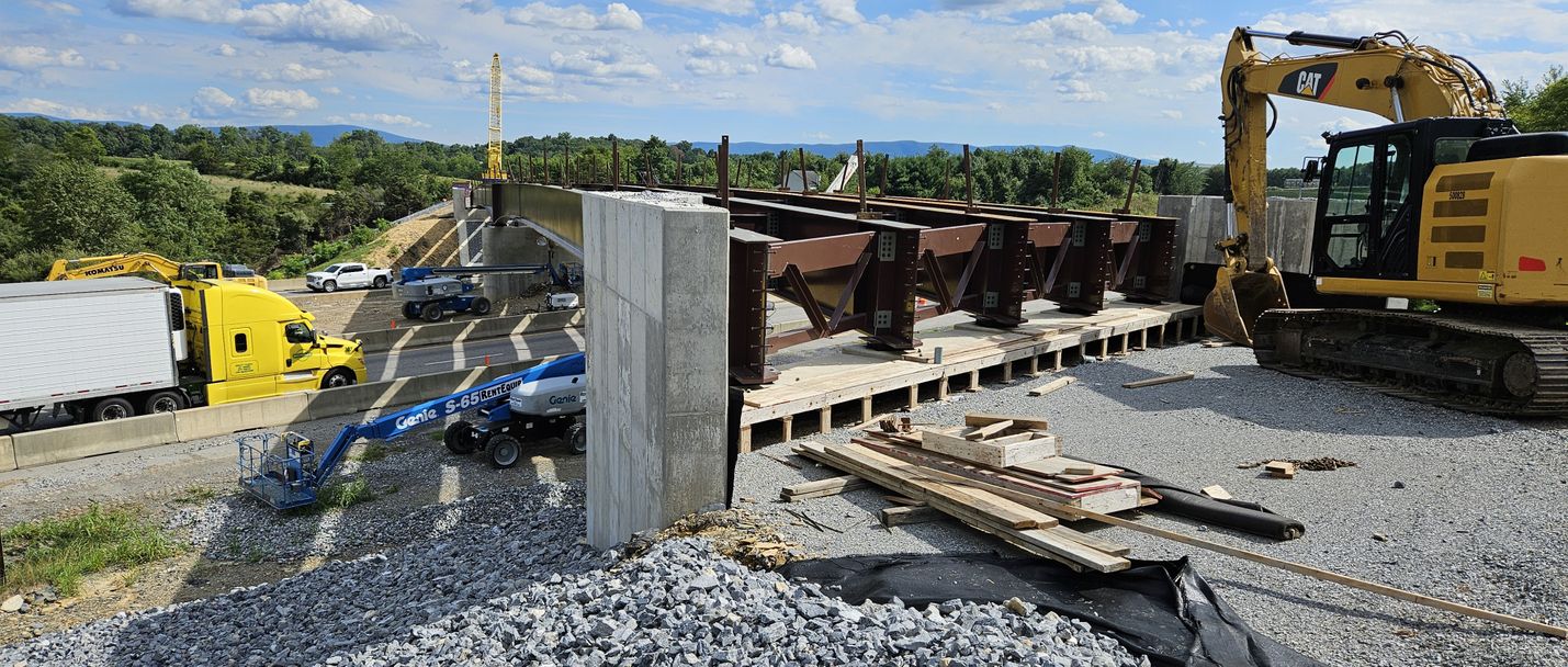 Bridge under construction over an interstate highway, which traffic passing underneath on a sunny day