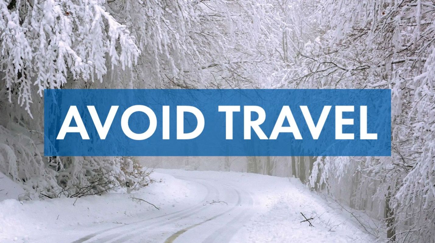 Snow- and ice-covered roadway in a wooded area along with the words, avoid travel