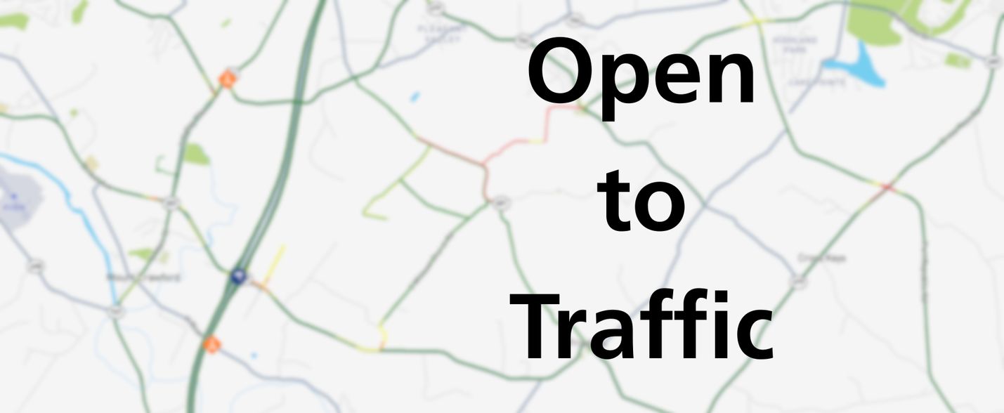 Blurred map overlaid with the words Open to Traffic