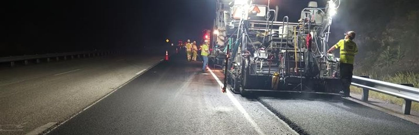 A paving crew works during nighttime hours