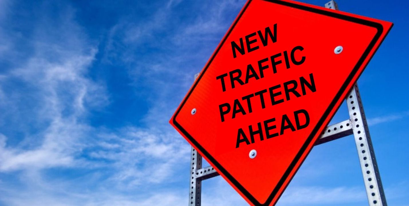 NEW TRAFFIC PATTERN AHEAD on an orange diamond-shaped sign against a blue sky