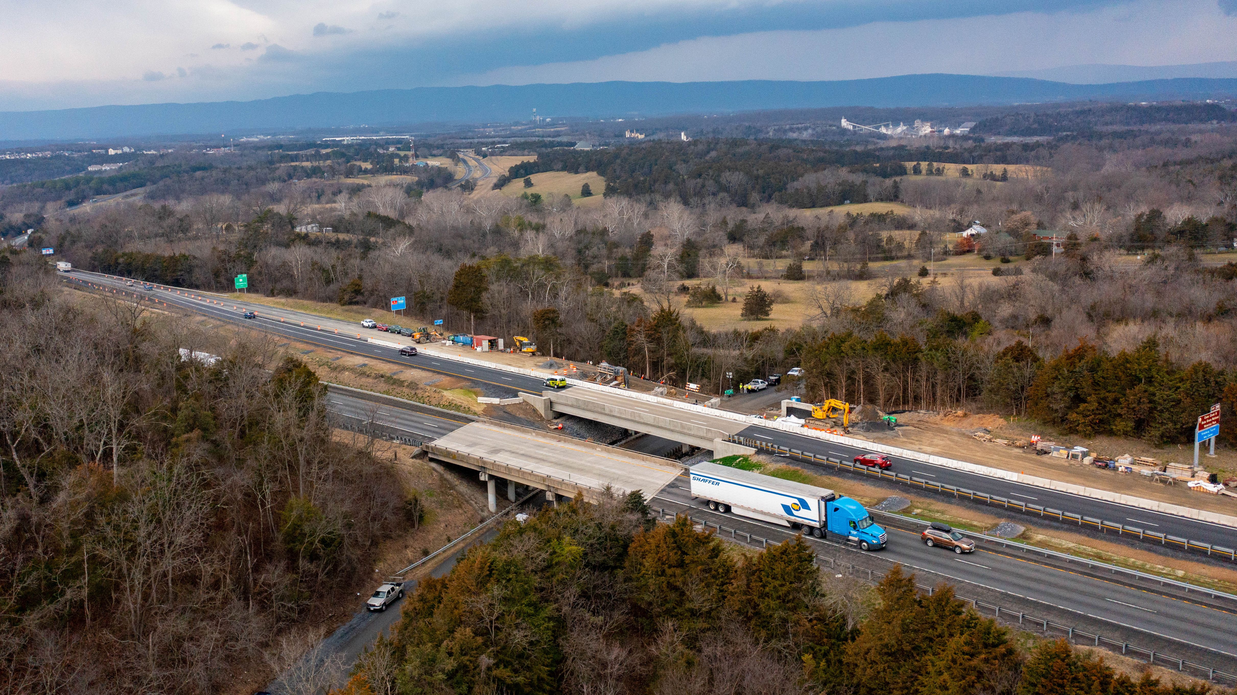 a drone photo of I-81 with cars and trucks on the road and mountains in the background