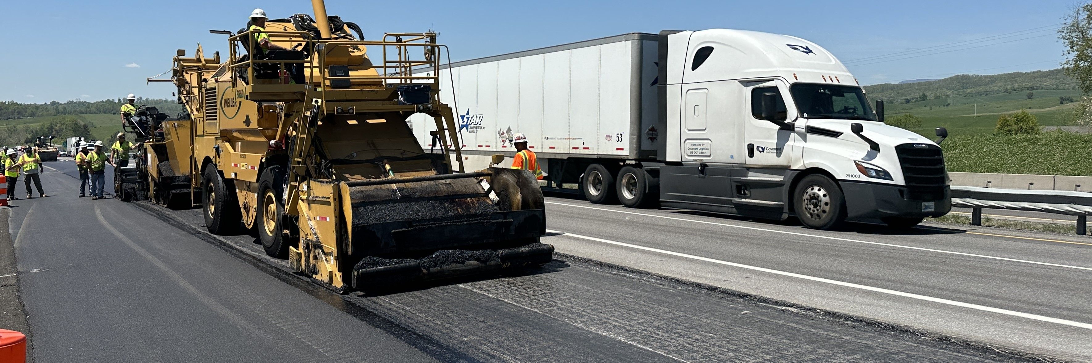 Paving equipment and personnel working next to traffic on a multi-lane highway